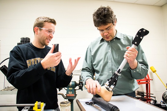 Student consulting with technician on senior design project.