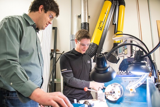 Technician and student working in machine shop