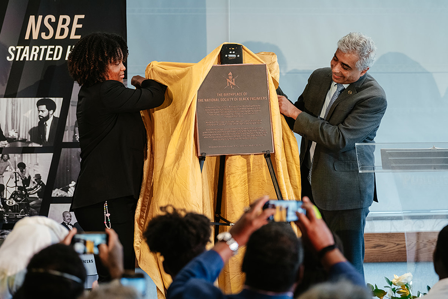 Student and dean revealing 50th anniversary NSBE plaque