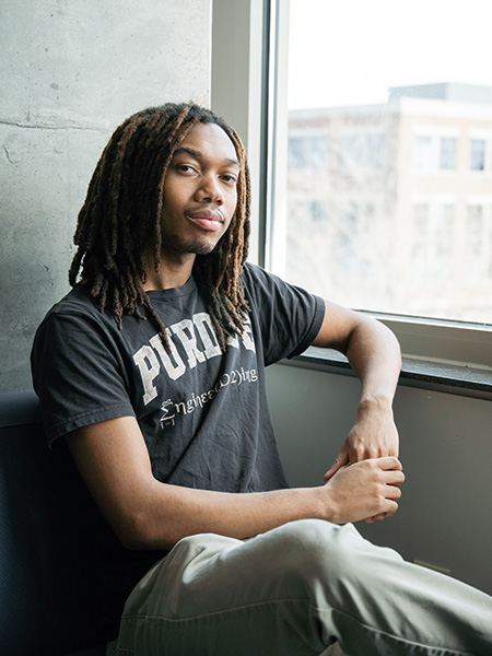 Student leaning against a window sill