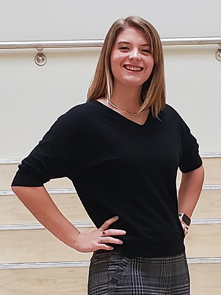 Student with long blonde hair, smiling, wearing black shirt