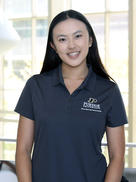 Student with dark hair, smiling, wearing Purdue polo shirt
